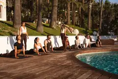 Group seated by the pool during a wellness session in Ibiza